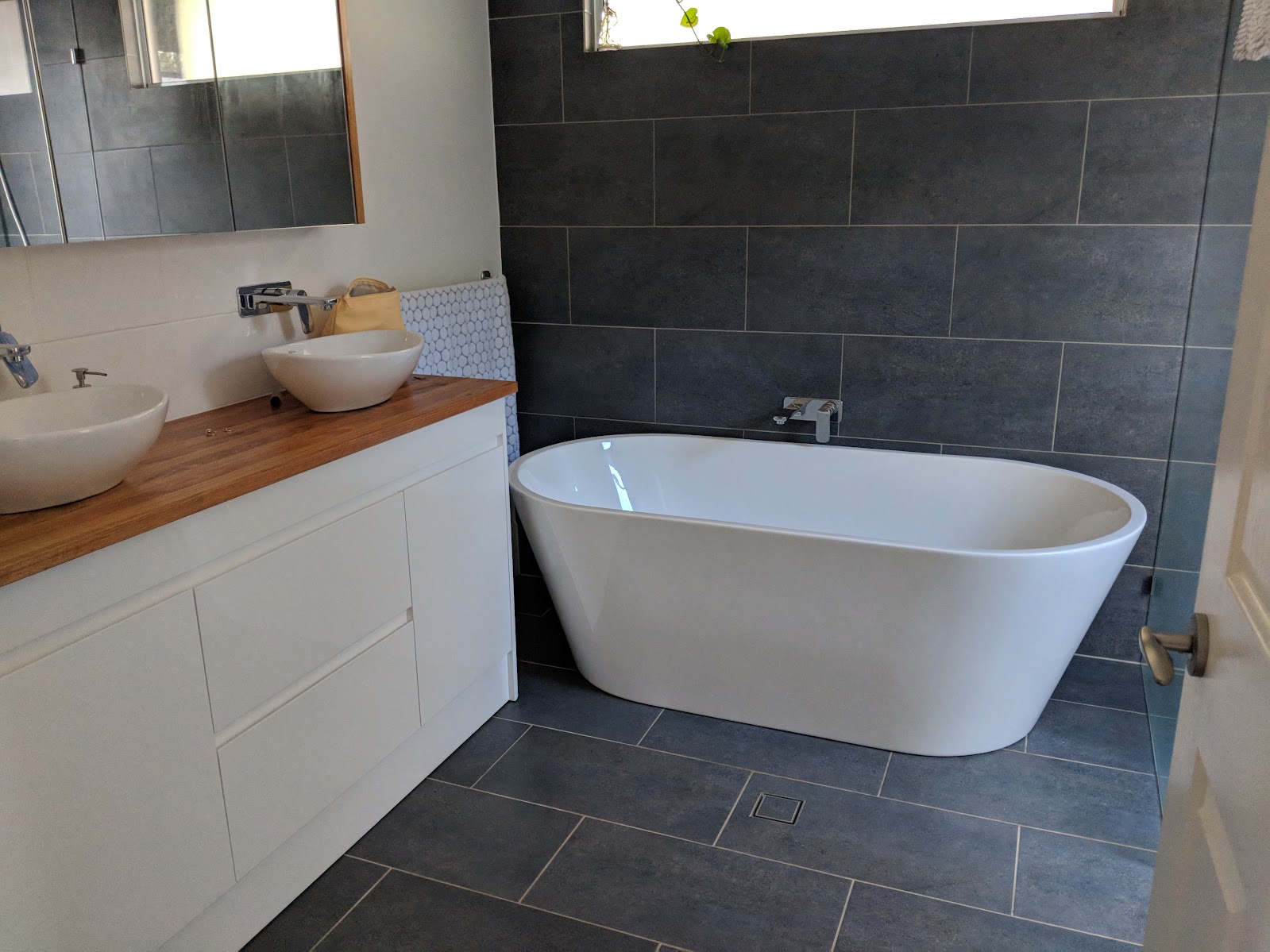 Completed bathroom with freestanding bath and timber vanity
