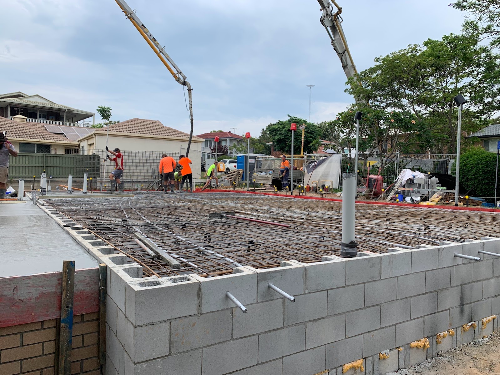 Crew pouring concrete slab on a residential build
